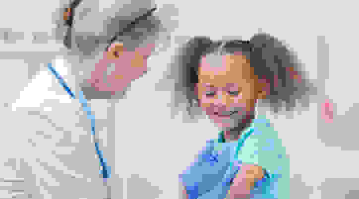 Doctor administering shot to young child