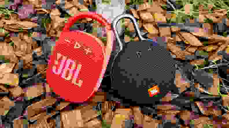 JBL Clip 4 and Clip 3 against tree on woodchips