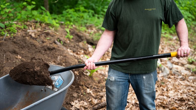A person who digs up dirt with the Fiskars Digging Shovel