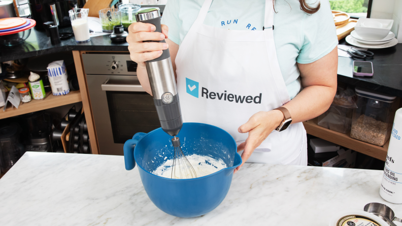 Person using GE Immersion Blender with whisk attachment to make whipped cream in a bowl