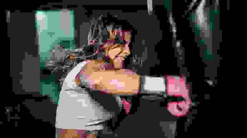 A woman hitting a punching bag at the gym.