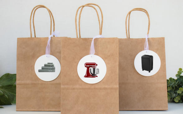 Three brown gift bags on a table with gift tags on them