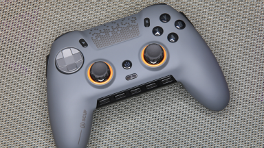 Gray Scuf Envision Pro gaming controller on top of gray cloth surface.