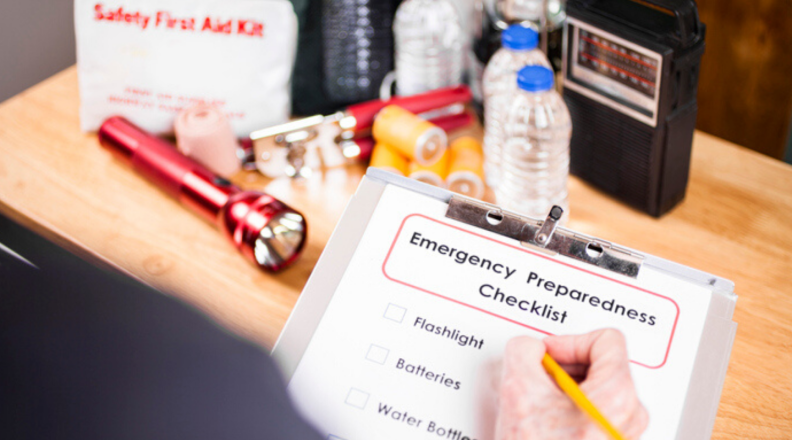 The image shows an emergency preparedness checklist and supplies.