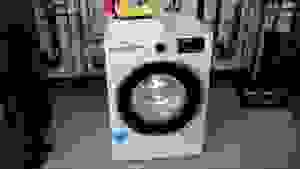 The white washing machine sits in the Reviewed Labs with its drum light on.