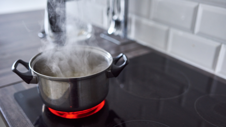 Pot of water boiling on a hot electric stove in a kitchen