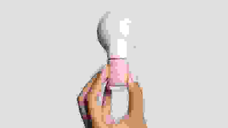 A hand holding up the Poppy nail polish.