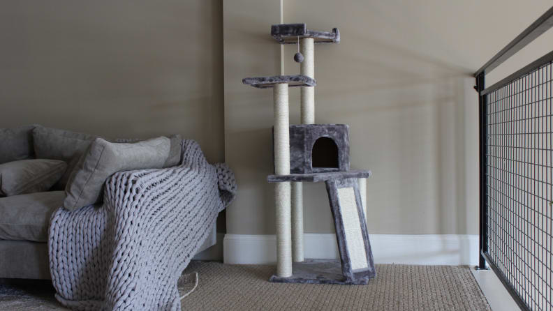 An image of a cat tree in a room with a sofa.