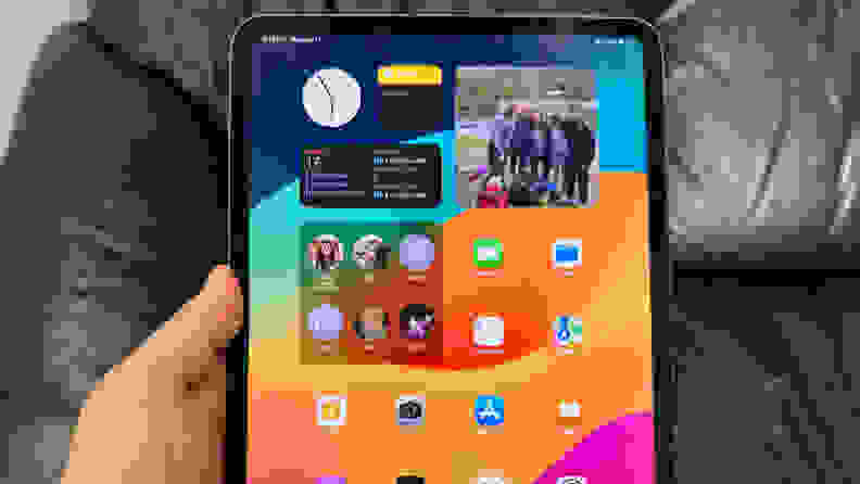 An iPad Pro being held by it's user in a portrait orientation.