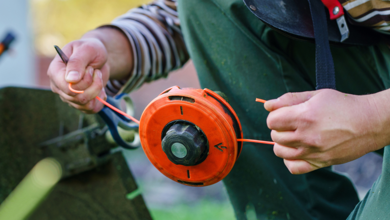 A person pulls the strings of a weed wacker.