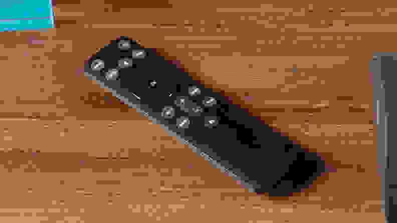 A remote for the Vizio M-Series All-in-One M213AD-K8 Dolby Atmos Soundbar on a wooden tabletop surface.