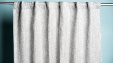grey curtain hanging against light blue background