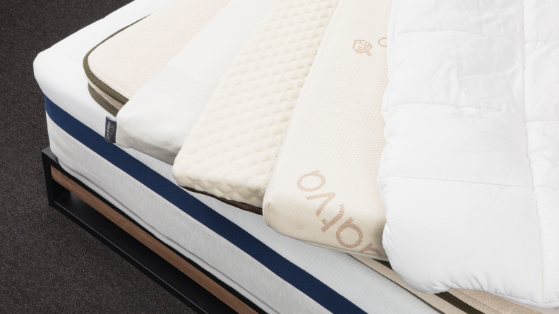 An array of mattress toppers spread on a mattress.