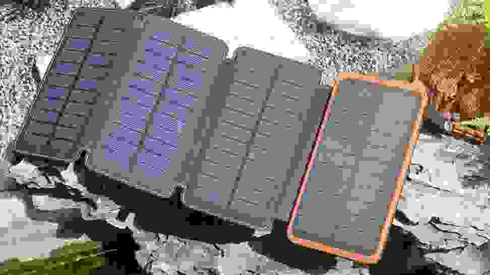 A small, foldable solar charger is on display with four panels, each made up of smaller rectangular cells.