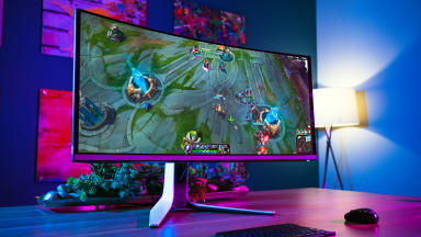 A gaming monitor standing on a desk with a multicolor background