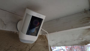 Product of mounted Ring Spotlight Cam Pro security camera on ceiling outside of home.