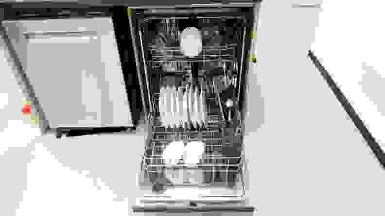 A shot of the dishwasher with its door opened fully and its lower rack pulled out. Both the lower and upper rack contain clean dishes.