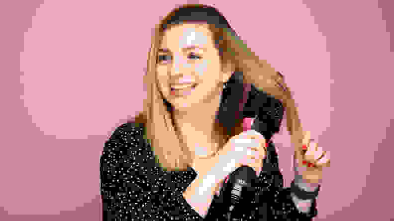 A photo of a woman using the Revlon One-Step Hair Dryer and Volumizer.