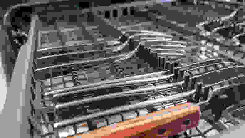 A close-up of cutlery lined up on the GE Profile PDP715SBNTS dishwasher's third rack.