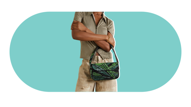 A model holding a beaded green bag.