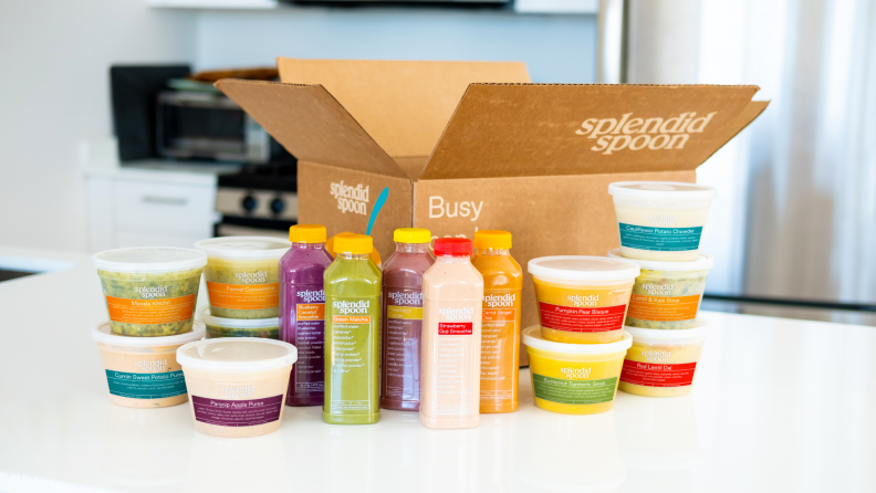 A Splendid Spoon Box on a white countertop surrounded by packaged soups and drinks.