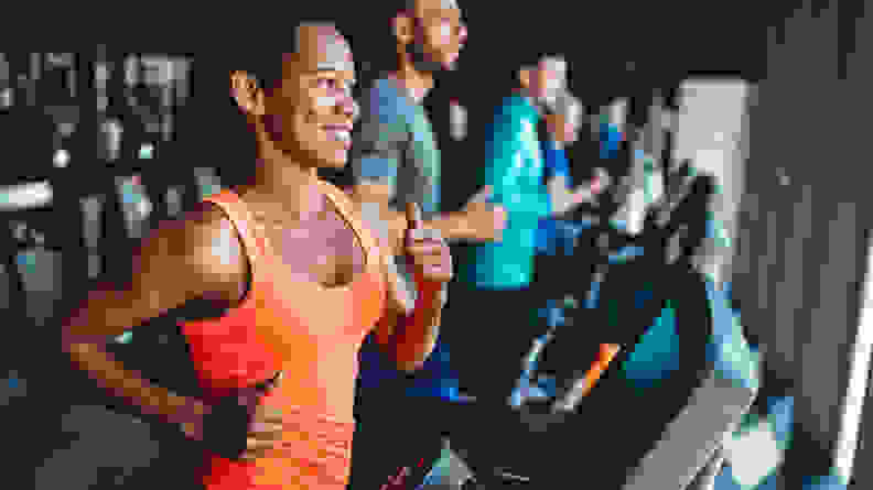 A woman running on a treadmill in the gym.