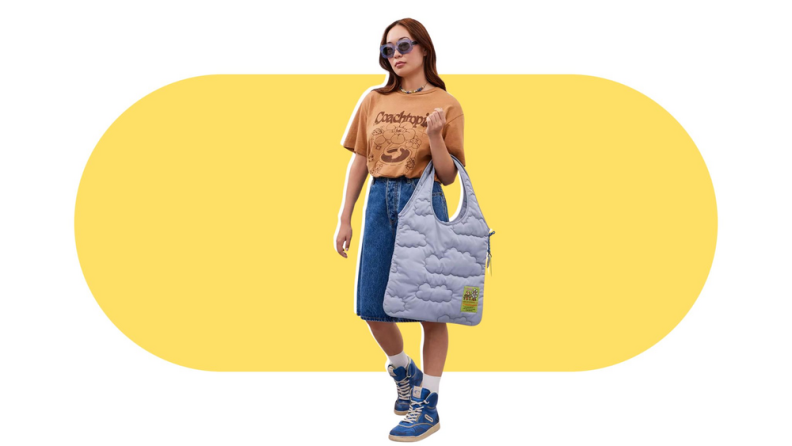 A model holding a light blue quilted tote bag.