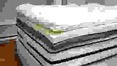 Close-up photo of a foam mattress topper and other layers of bedding.