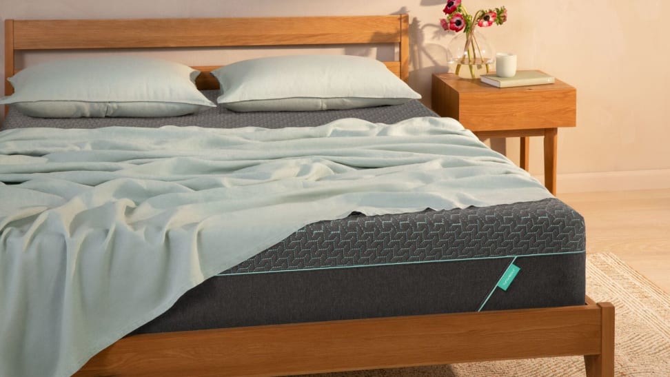 A Tuft & Needle Mattress with a light blue/grey sheet on top.