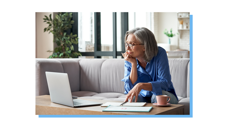 An older lady looking over her laptop.