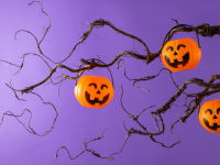 Stock image of a Halloween tree with gnarled limbs and pumpkin basket decorations.