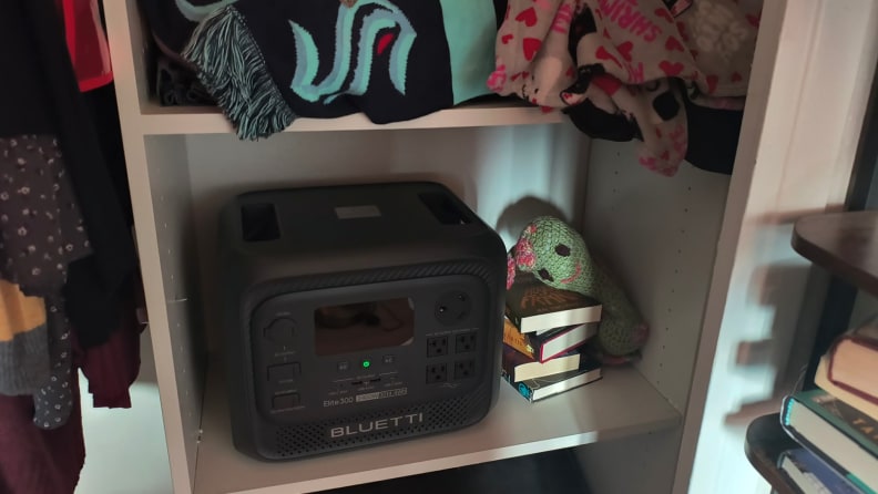 Elite 300 in a cubby in a closet next to a stack of books and a plush snail