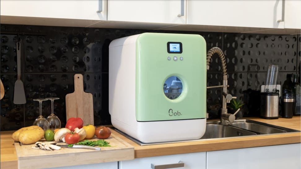 The Bob Global dishwasher sits on a kitchen counter, next to a sink.