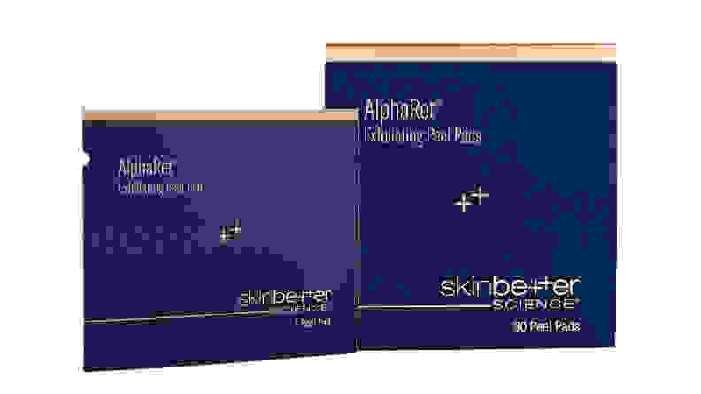A navy blue box and a packet of exfoliating pads side by side on a white background.