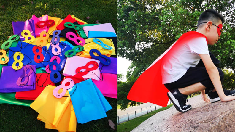 A pile of colorful kids capes and masks and a photo of a boy crouched on a rock wearing a red cape and mask