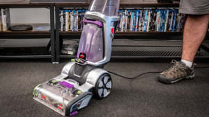 A person using a Bissell carpet cleaner