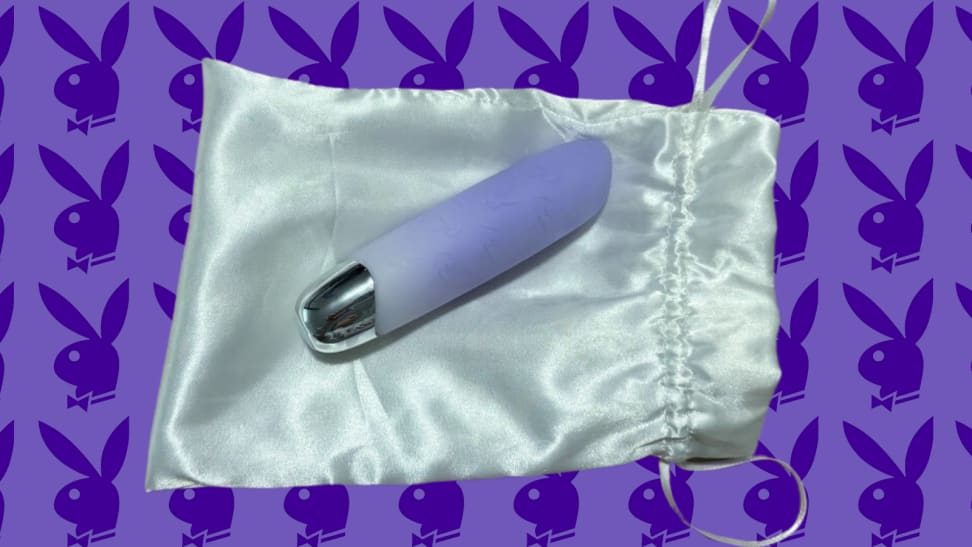 Playboy vibrator on a silk bag on a purple background