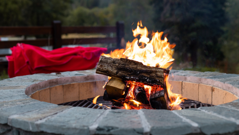 Fire pit with burning logs inside.