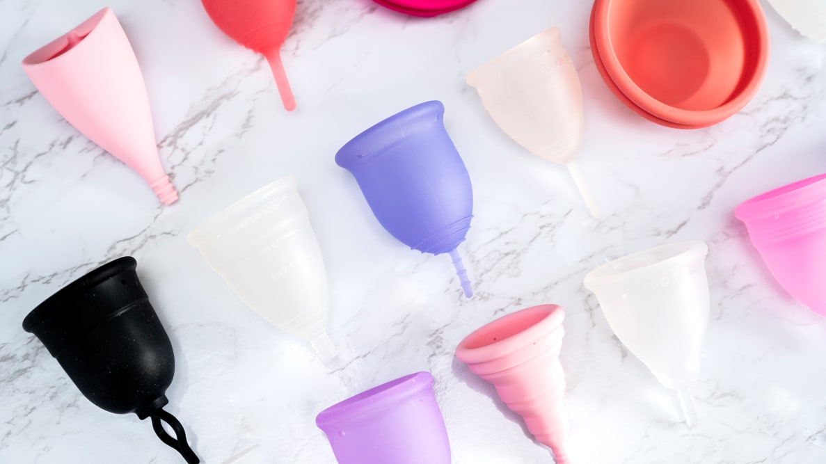 colorful menstrual cups on white marble background