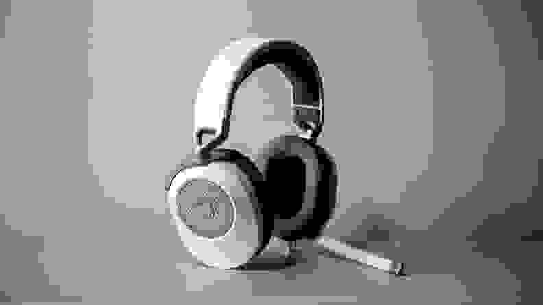 A pair of white headphones against a beige backdrop