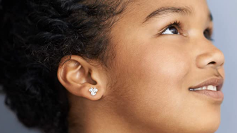 A little girl wearing Minnie Mouse earrings