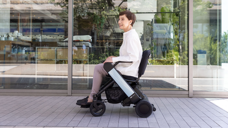 A person rides in the Whill electric wheelchair.