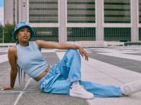 person posing in light wash wide leg jeans with white sneakers