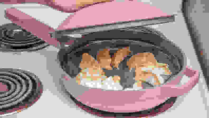 Pink pan with dumplings steaming inside.