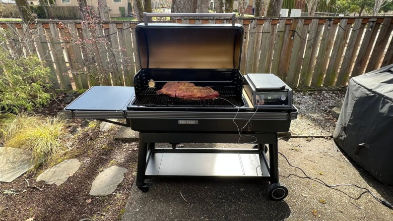 The Traeger Ironwood XL Pellet Grill outside with a piece of meat on the grill.