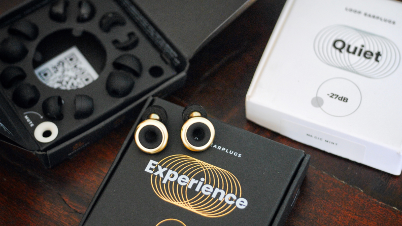 Gold and black loop earbuds sitting on top of black box packaging.