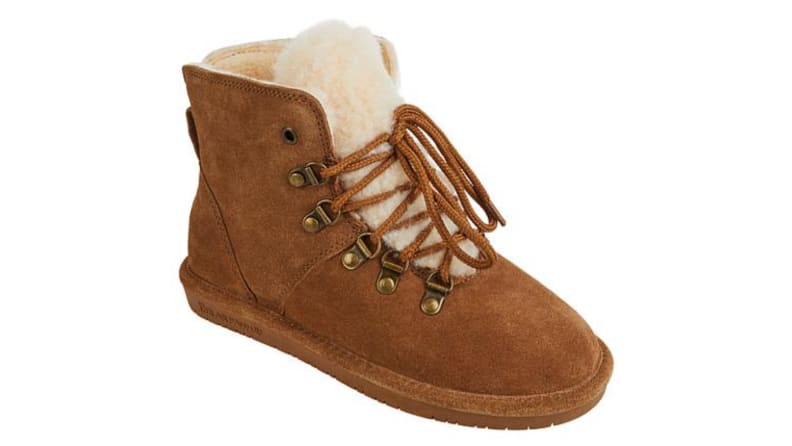 An image of a single lace-up suede boot in warm brown with a fluffy sherpa interior.