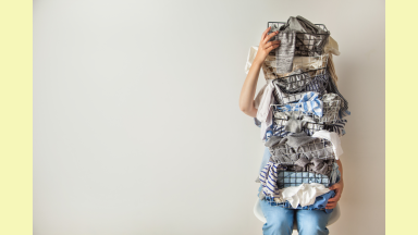 Image of a person holding a stack of clothes.