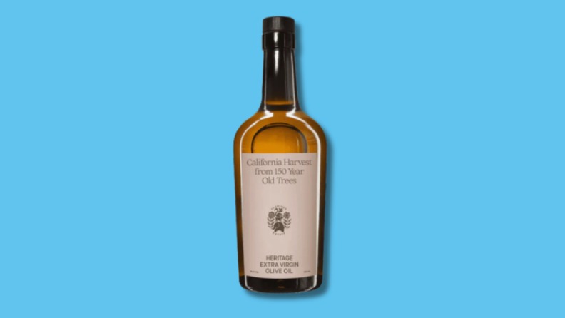 Single bottle of Flamingo Estate Heritage Extra Virgin Olive Oil in front of blue background.