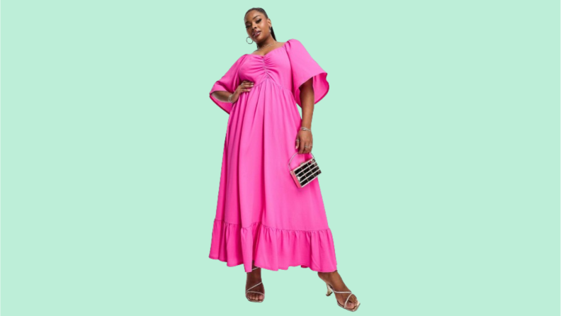 A model wearing a pink maxi dress with bell sleeves.